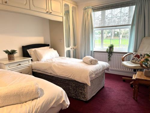 a bedroom with two beds and a window at Upperton Townhouse in Eastbourne