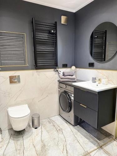 a bathroom with a washing machine and a sink at Justinrent 1 in Legnica
