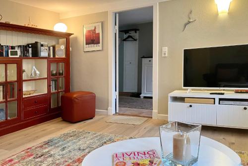 a living room with a large flat screen tv at Haus 25 in Oldsum in Oldsum