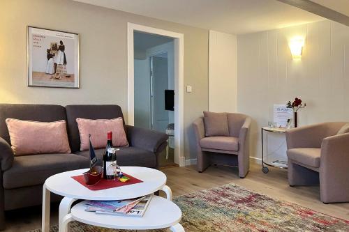 a living room with a couch and chairs and a table at Haus 25 in Oldsum in Oldsum