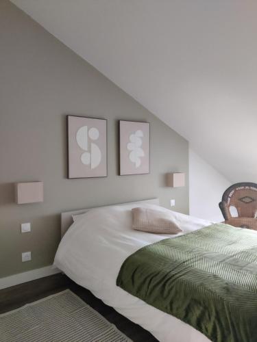 a bedroom with a bed with three pictures on the wall at Grand appart 2 chambres - Hyper centre - Calme in Chinon