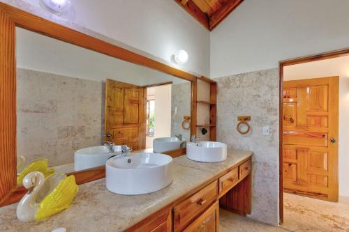 a bathroom with two sinks and a large mirror at Río Mar Cumayasa in La Romana
