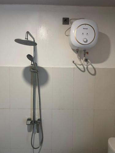 a shower in a bathroom with a shower head at Peony Villa Lovina in Lovina