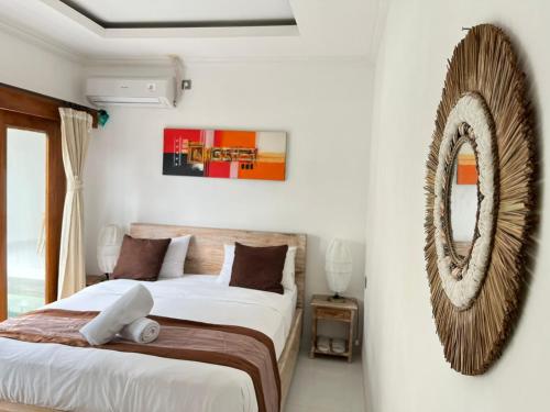 a bedroom with two beds and a mirror on the wall at Peony Villa Lovina in Lovina