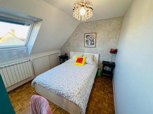 a bedroom with a bed with a yellow pillow on it at Close to Disney & Paris in Lagny