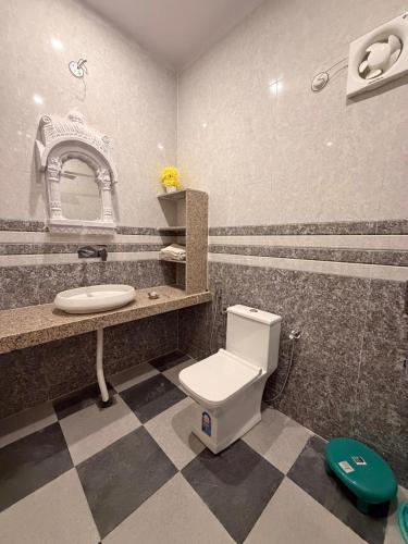 a bathroom with a toilet and a sink and a mirror at Hotel Shekhawati Mandawa in Mandāwa