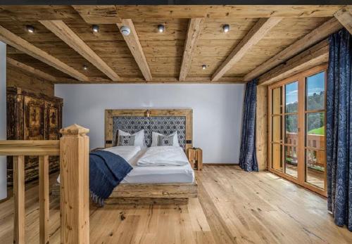 a bedroom with a bed and a wooden ceiling at Ascherhof in Thiersee