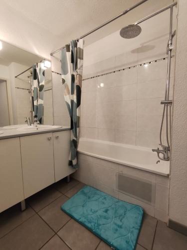 a bathroom with a tub and a sink and a shower at nice apartment strategic location in Muret