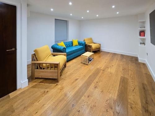 a living room with a blue couch and two chairs at Luxury Apartment next to Parliament Square in London
