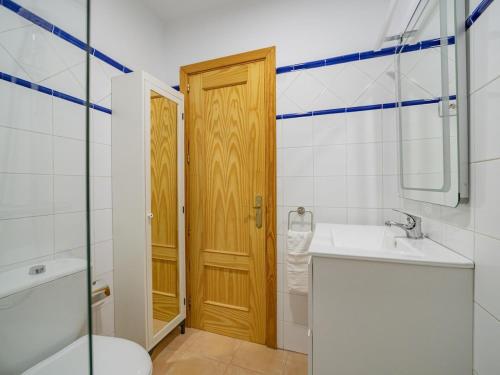 a bathroom with a sink and a wooden door at CHL La Mareta, cozy apartment with pool in Breña Baja