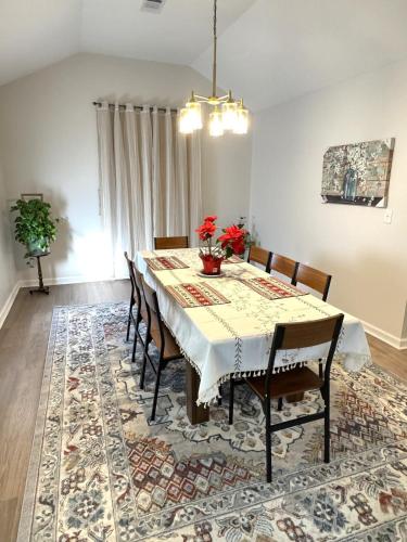 a dining room with a table and chairs on a rug at Brand new spacious and comfort 3-bedroom villa in east central in Memphis