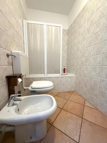 a bathroom with a white toilet and a sink at Villa crotto Lake View in Perledo