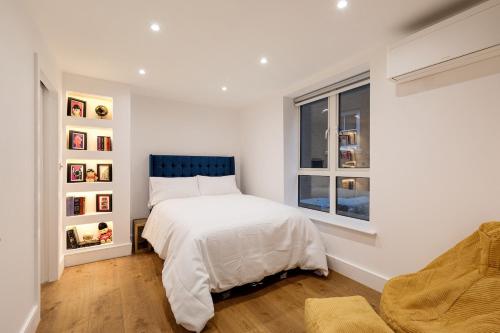a white bedroom with a bed and a window at Luxury Apartment next to Parliament Square in London