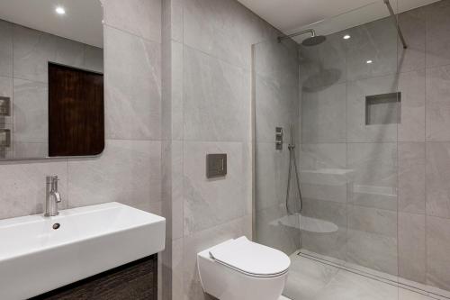 a bathroom with a sink and a toilet and a shower at Luxury Apartment next to Parliament Square in London