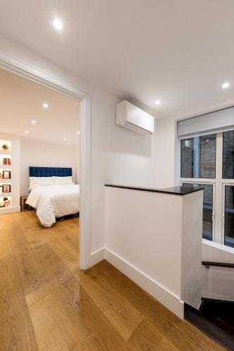 a white bedroom with a bed and a window at Luxury Apartment next to Parliament Square in London