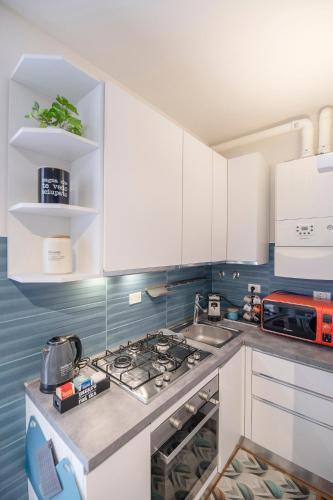 a kitchen with white cabinets and a stove top oven at Vdoppia Apartment in San Giovanni in Persiceto
