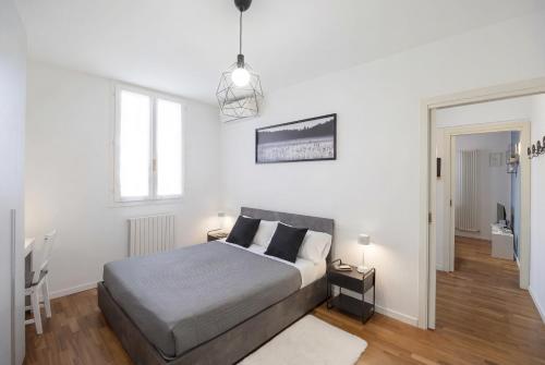 a bedroom with a bed in a white room at Vdoppia Apartment in San Giovanni in Persiceto