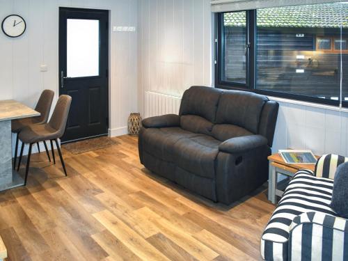 a living room with a leather couch and a table at Lodge 5 - Uk51086 in Lyme Regis