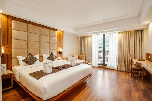 a hotel room with a large bed and a desk at Hotel Square Plaza At Airport in New Delhi