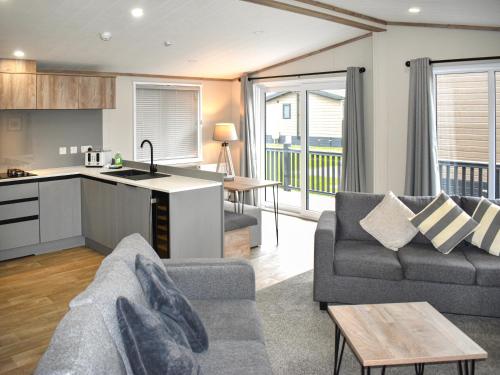 a living room with a couch and a kitchen at Lodge 8 - Uk51076 in Lyme Regis
