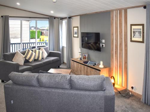 a living room with a couch and a tv at Lodge 8 - Uk51076 in Lyme Regis