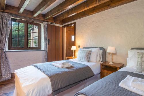 a bedroom with two beds and a window at Coach House in Pembroke