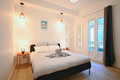 a bedroom with a bed with white sheets and a window at Résidence Sébastopol - Appartements Hyper Centre - WiFi & Smart TV in Béziers