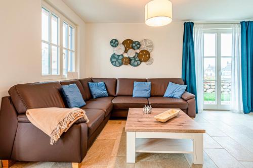 a living room with a brown couch and a table at Kramerhof Rügenblick Nr 30 in Parow