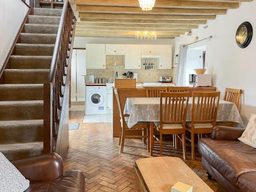 a kitchen and living room with a table and chairs at Honeysuckle Cottage - 27880 in Elton
