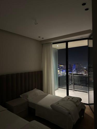 ein Schlafzimmer mit einem Bett und einem großen Fenster in der Unterkunft Renas apartment 4 in Tirana