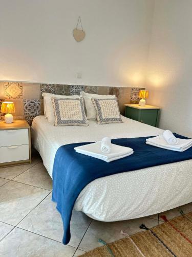 a bedroom with a large bed with two towels on it at Casa João Bravo in Albufeira