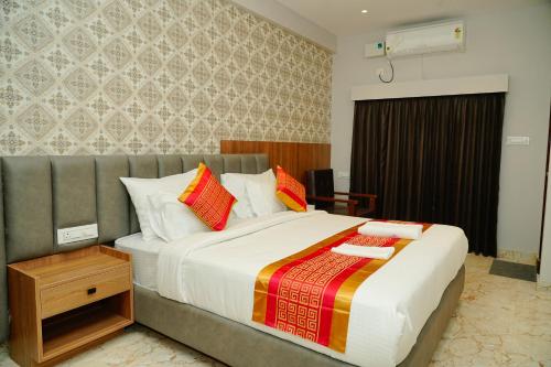 a bedroom with a large bed with colorful pillows at AAryavarth suites 46 in Pālasmudram