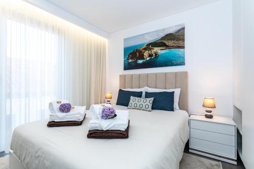 a bedroom with a large white bed with two towels at GuestReady - Passal Guesthouse in Ponta Delgada