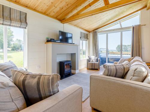 a living room with two couches and a fireplace at Nanny Goat Lodge in Crossway Green