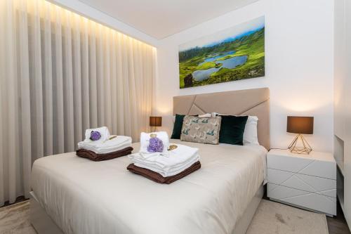 a bedroom with a white bed with two pillows at GuestReady - Passal Guesthouse in Ponta Delgada