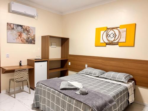 a bedroom with a bed and a desk in it at Pousada Luz do El Shaday in Barreirinhas