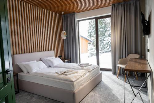 a bedroom with a bed and a large window at Gogodz Chalet Resort in Yablunytsya