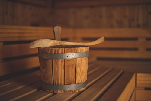a wooden cup with two wooden utensils in it at Hotel Post Sils Maria in Sils Maria