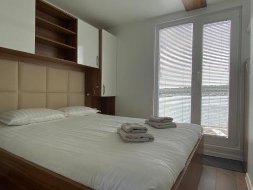 a bedroom with a bed with towels on it at Hausboot Pula - Floating House Water Lily in Pula