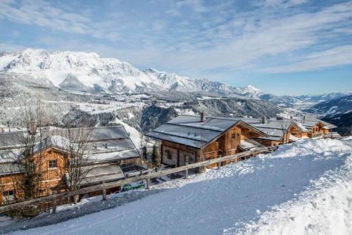 a cabin in the snow with mountains in the background at Chalet Torstein in Schladming