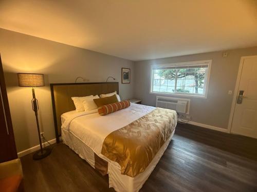 a bedroom with a large bed and a window at Naval Suites by FairBridge in Bremerton