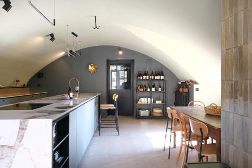 una cucina mansardata con un arco e un'isola di Château de Lemps a Lemps