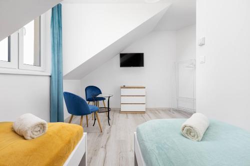 a bedroom with two beds and a table and a chair at Halinówka Goniądz in Goniadz