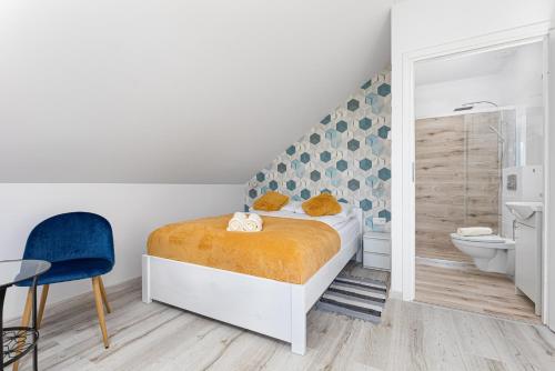 a white bedroom with a bed and a bathroom at Halinówka Goniądz in Goniadz