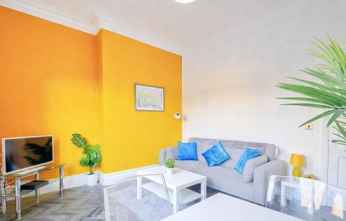 a living room with a couch and a yellow wall at The Norton Apartment by GR Estates in Stockton-on-Tees