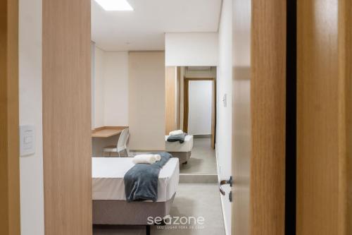 a bedroom with a bed and a desk in a room at Apts in a Building with Pool and Gym - GRL in Anápolis