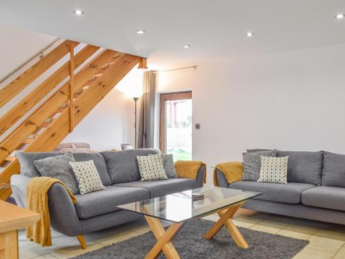 a living room with two couches and a table at Mill House Barn in Warmingham