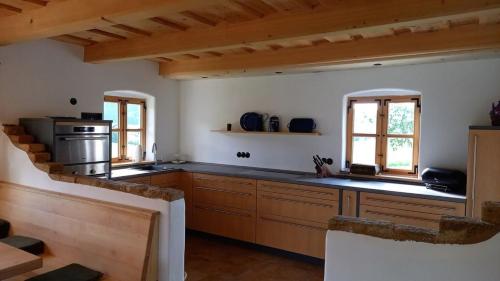 a large kitchen with wooden cabinets and a stove at Chalet Schmuckkastal in Kollnburg