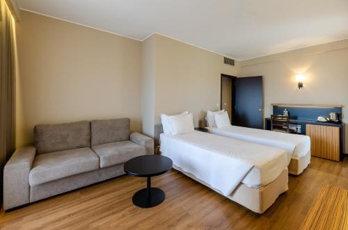 a hotel room with a bed and a couch at TURIM Santa Maria da Feira Hotel in Santa Maria Da Feira
