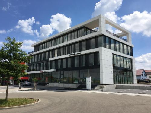 un gran edificio de oficinas con muchas ventanas en Toploft The Aparthotel en Crailsheim